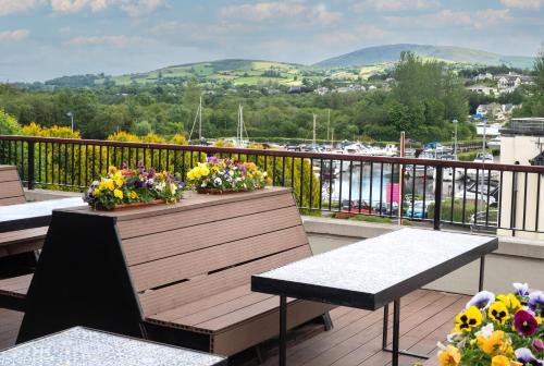 a balcony with two benches and flowers on it at Killaloe Hotel & Spa in Killaloe