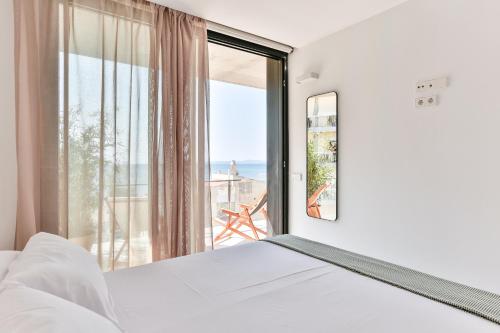 a bedroom with a bed and a large window at ECO-APARTMENTS LA MARINEDA in Roses