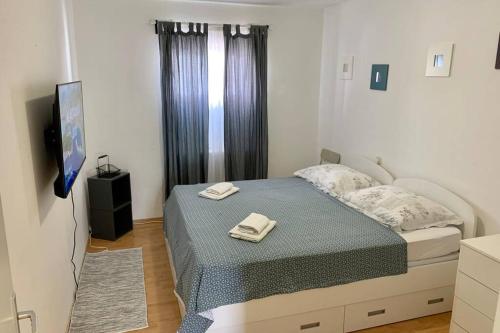 1 dormitorio con 1 cama con 2 toallas en Summer apartment 4, en Makarska