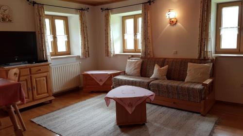 a living room with a couch and a tv at Ferienwohnung Ertlerlehen in Marktschellenberg