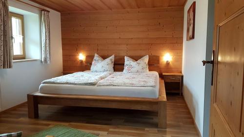 a bedroom with a bed with two pillows on it at Ferienwohnung Ertlerlehen in Marktschellenberg