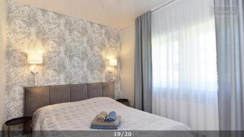 a bedroom with a bed with two slippers on it at Villa Elena in Ventspils