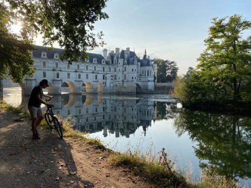 a man riding a bike in front of a castle at La Chancellerie in Montrichard