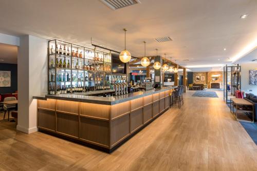 a bar in a restaurant with a lot of alcohol at Holiday Inn Cambridge by IHG in Cambridge
