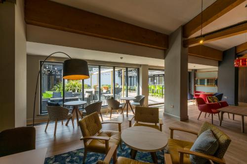 a lobby with tables and chairs and a patio at Holiday Inn Cambridge by IHG in Cambridge