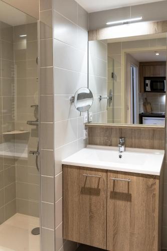 une salle de bain avec un lavabo et un miroir dans l'établissement Residhome Toulouse Ponts Jumeaux, à Toulouse