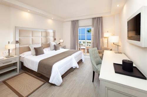 a hotel room with a large bed and a desk at Hotel RIU Garoé in Puerto de la Cruz