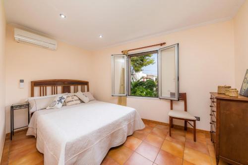 a bedroom with a bed and a window at Finca Coll in Alcudia