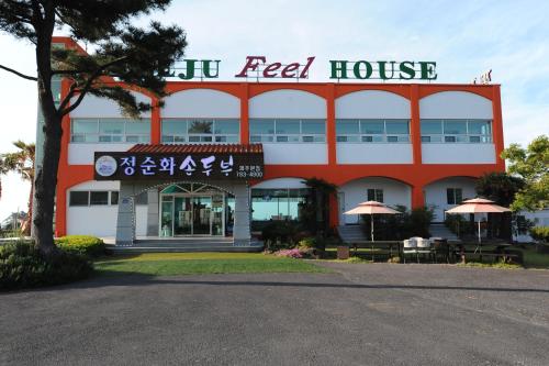a red and white building with a sign on it at Jeju Feel House in Jeju
