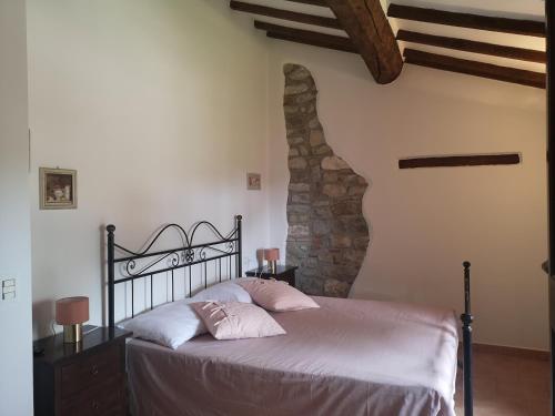 a bedroom with a bed and a stone wall at Ryan Apartment in Passignano sul Trasimeno