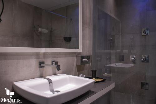 a bathroom with a white sink and a mirror at Megaris Luxury Suite Rooms in Naples