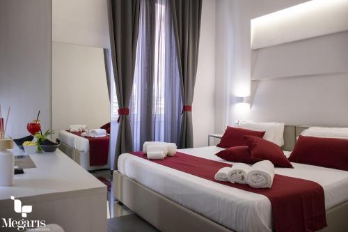 a bedroom with two beds with red and white pillows at Megaris Luxury Suite Rooms in Naples