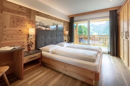 a bedroom with a bed and a large window at Apartments La Mana in Santa Cristina Gherdëina