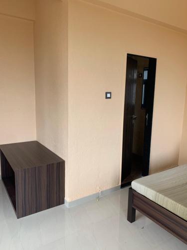 a room with a bed and a wooden cabinet next to a door at ROYAL MEADOWS - IGATPURI Bungalow C in Igatpuri