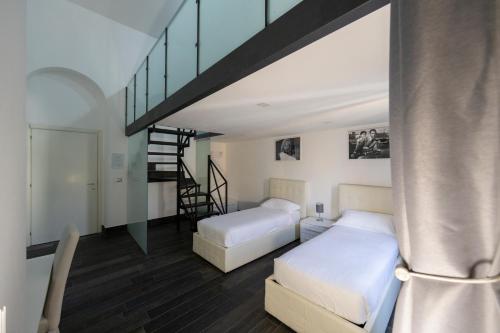 a bedroom with two beds and a staircase at Arch Rome Suites in Rome