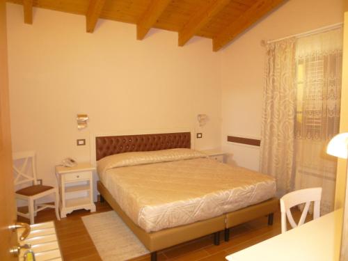 1 dormitorio con cama, mesa y ventana en Relais Villa Giulia, en Bastia Umbra