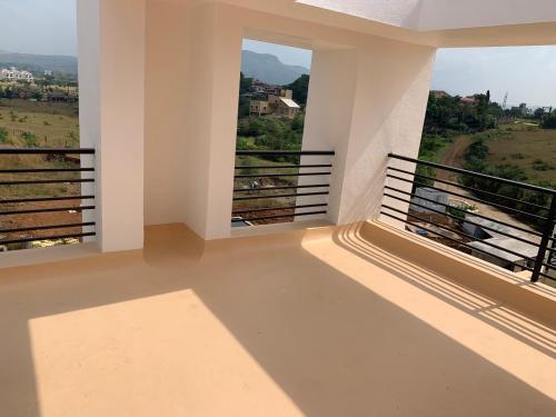 a balcony with two windows and a view of a field at ROYAL MEADOWS - IGATPURI Bungalow C in Igatpuri