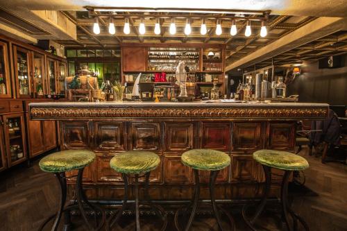 a bar with two stools and a counter in a room at Hotel B Berdichevsky in Tel Aviv