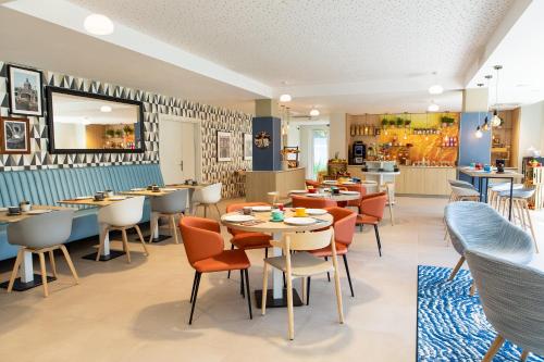 a restaurant with tables and chairs and a cafeteria at Residhome Toulouse Ponts Jumeaux in Toulouse