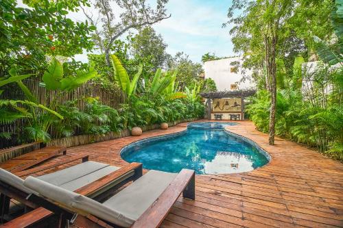 una piscina en un patio con terraza de madera en Eco-chic Design Condos Wrapped in Nature's Elements by Stella Rentals, en Tulum