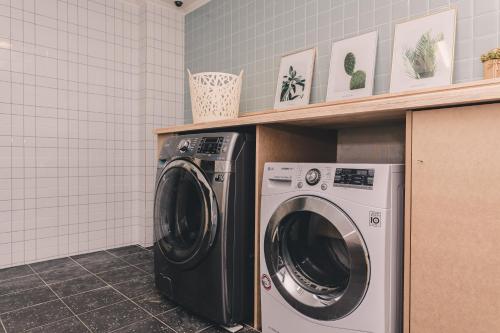 a washer and dryer in a laundry room at Aria Hotel in Seogwipo