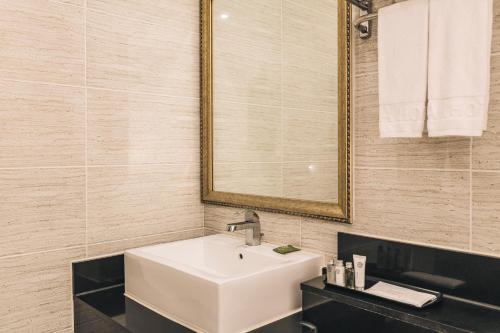 a bathroom with a white sink and a mirror at Aria Hotel in Seogwipo