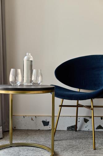 a table and a chair with wine glasses on it at Hotel Liberte 33 BW Premier Collection in Poznań