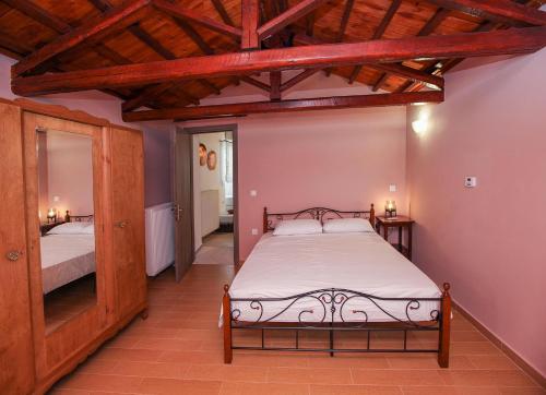 sypialnia z łóżkiem i dużym lustrem w obiekcie Traditional Guesthouse Asimakis Anifion w mieście Anífion