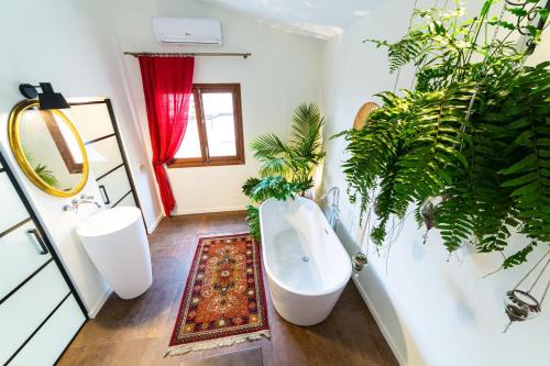 baño con bañera blanca y plantas. en Flor de Mandarina en Sa Pobla