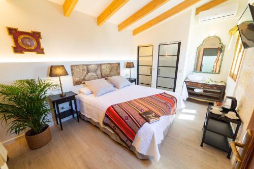 a bedroom with a bed and a plant in it at Flor de Mandarina in Sa Pobla