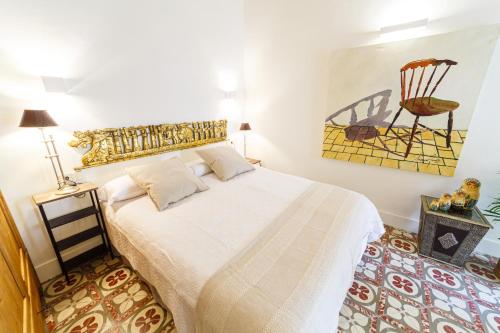 a bedroom with a bed and a chair on the wall at Flor de Mandarina in Sa Pobla