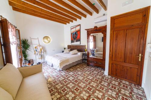 a bedroom with a bed and a couch at Flor de Mandarina in Sa Pobla