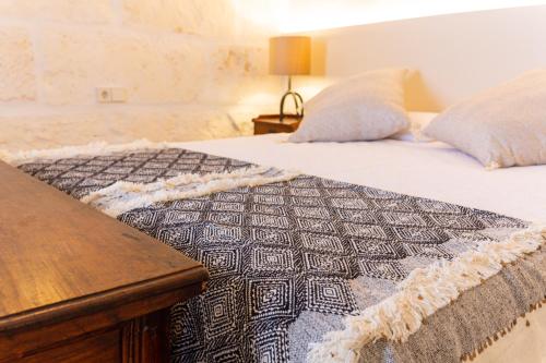 a bed with a black and white quilt on it at Flor de Mandarina in Sa Pobla