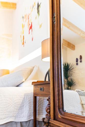 a mirror on a table next to a bed at Flor de Mandarina in Sa Pobla