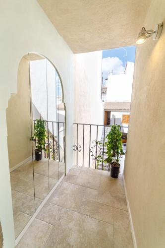 a balcony with potted plants and an archway at Flor de Mandarina in Sa Pobla