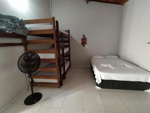 a room with a bed and bunk beds in it at Pousada Rita Brandão in Jijoca de Jericoacoara
