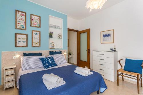 a bedroom with a blue and white bed and a chair at La Terrazza in Brunate