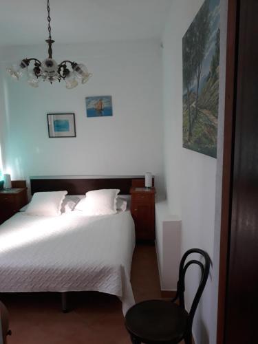 a bedroom with a white bed and a black chair at Apartment Božava - Nena in Božava