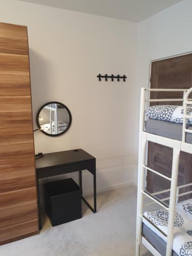 a bedroom with bunk beds and a desk and a mirror at Family apartmán Kovářská in Kovářská