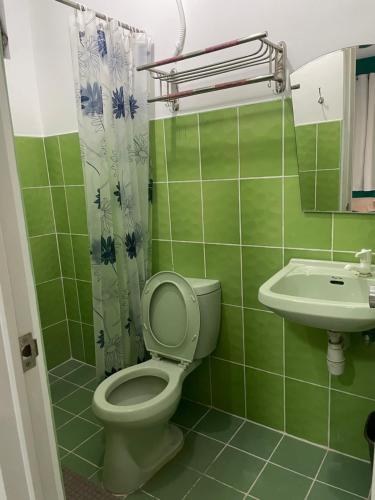 a green bathroom with a toilet and a sink at Your Choice Hotel in Catbalogan