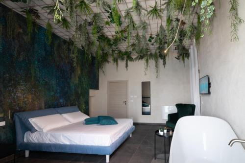 sypialnia z łóżkiem i roślinami na suficie w obiekcie Sonrisa suites w mieście Tarent