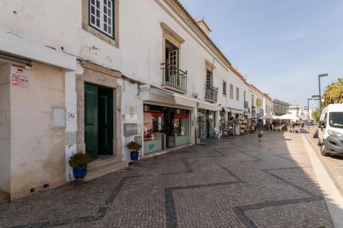 a cobblestone street in a city with buildings at Taah Billa Guest House in Tavira