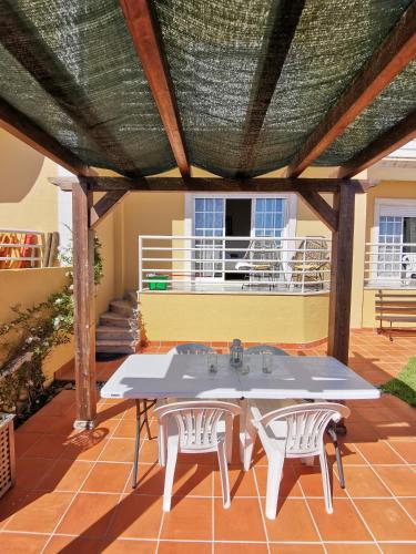 a patio with a table and two white chairs at Windmill Ericeira in Ericeira