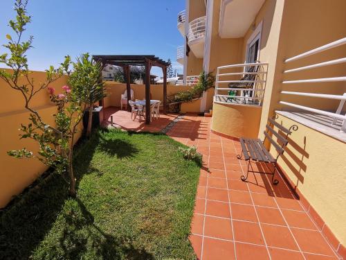 a patio with a bench next to a building at Windmill Ericeira in Ericeira