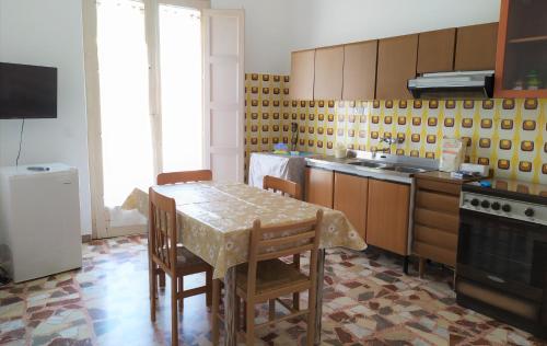 a kitchen with a table and chairs and a stove at B&B Casa Valentina a Linguaglossa in Linguaglossa
