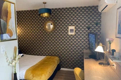 ein Schlafzimmer mit einem Bett und einem Schreibtisch mit einer Lampe in der Unterkunft Joli appartement haut standing en hyper centre in Toulouse