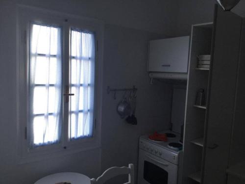 a small kitchen with a stove and a window at Makares in Donoussa