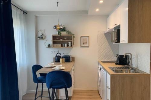 une petite cuisine avec une table et deux chaises bleues dans l'établissement Joli appartement haut standing en hyper centre, à Toulouse