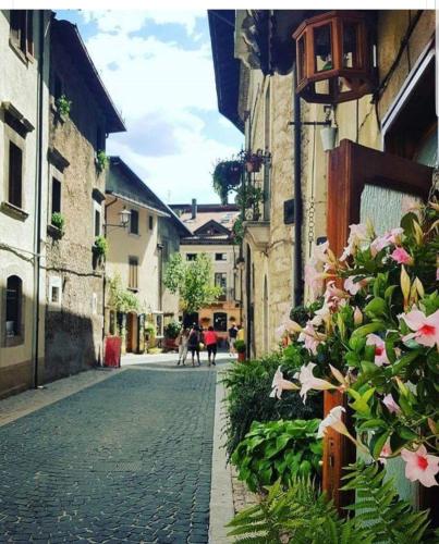una calle adoquinada en una ciudad con edificios y flores en Armida, en Pescasseroli