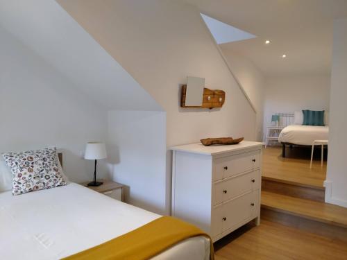 a bedroom with a white bed and a dresser and a room at Ca de Géraldine in El Pont de Suert